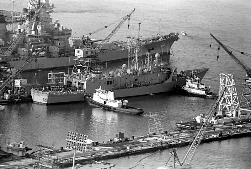 28 August 1988: Pascagoula, MS - Harbor tugs maneuver Stark toward the dock at Ingalls Shipbuilding after the ship underwent repairs 
                		    for damage sustained when It was struck by two Iraqi-launched Exocet missiles while on patrol in the Persian Gulf. The battleship Wisconsin (BB64), which will undergo sea trials, is visible to 
                		    the left of Stark.